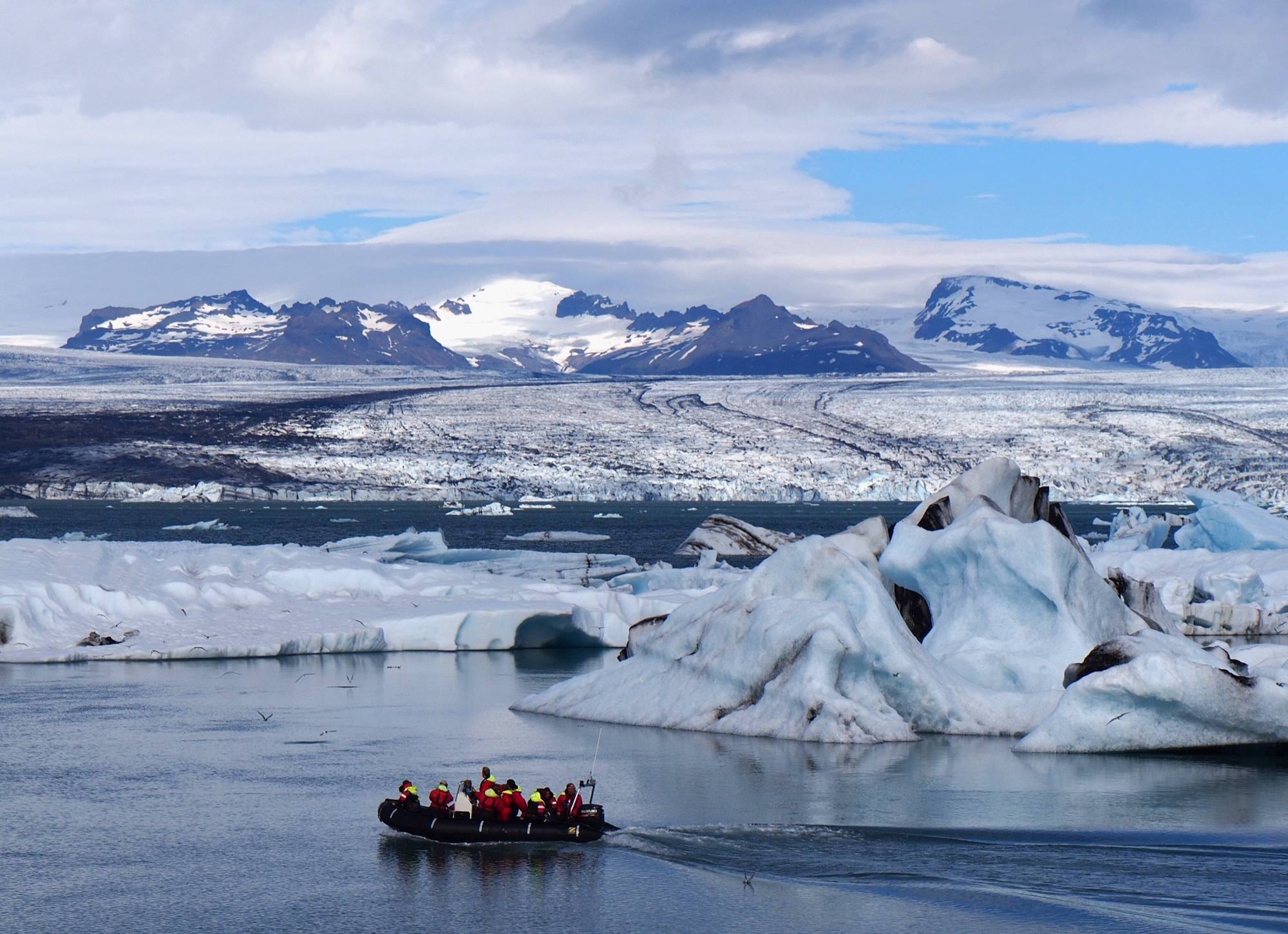 Zodiac zwischen blauen Eisbergen auf dem Jökulsárlón vor dem Gletscher